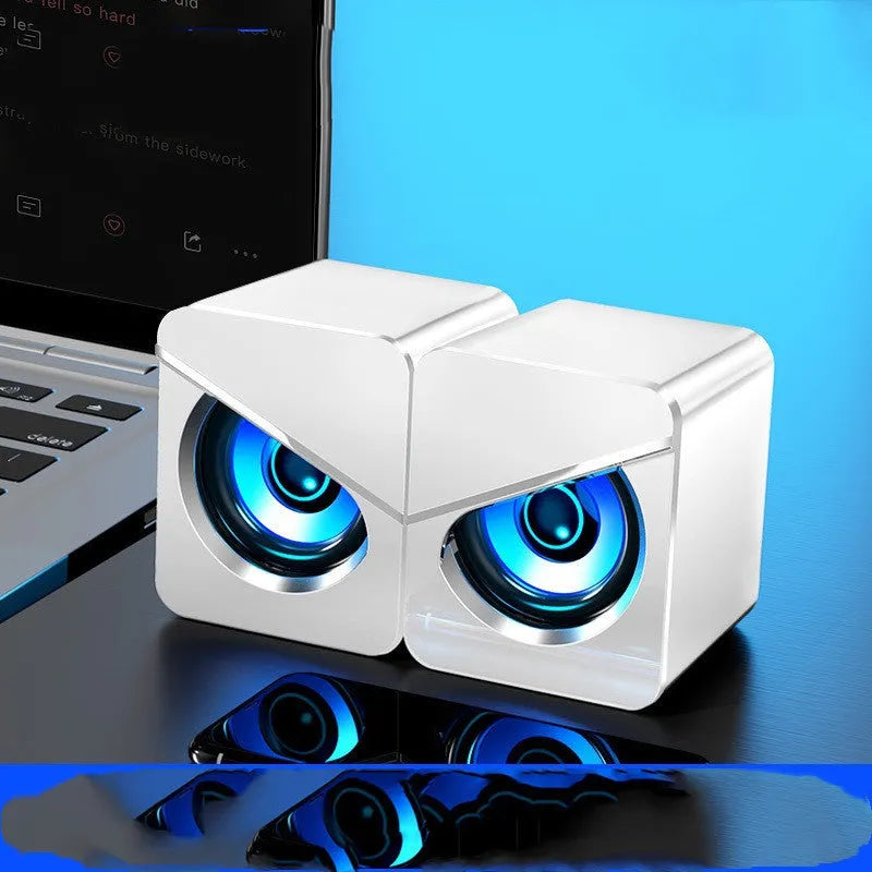 Small black and white desktop computer speakers with USB cable and 3.5mm audio connector