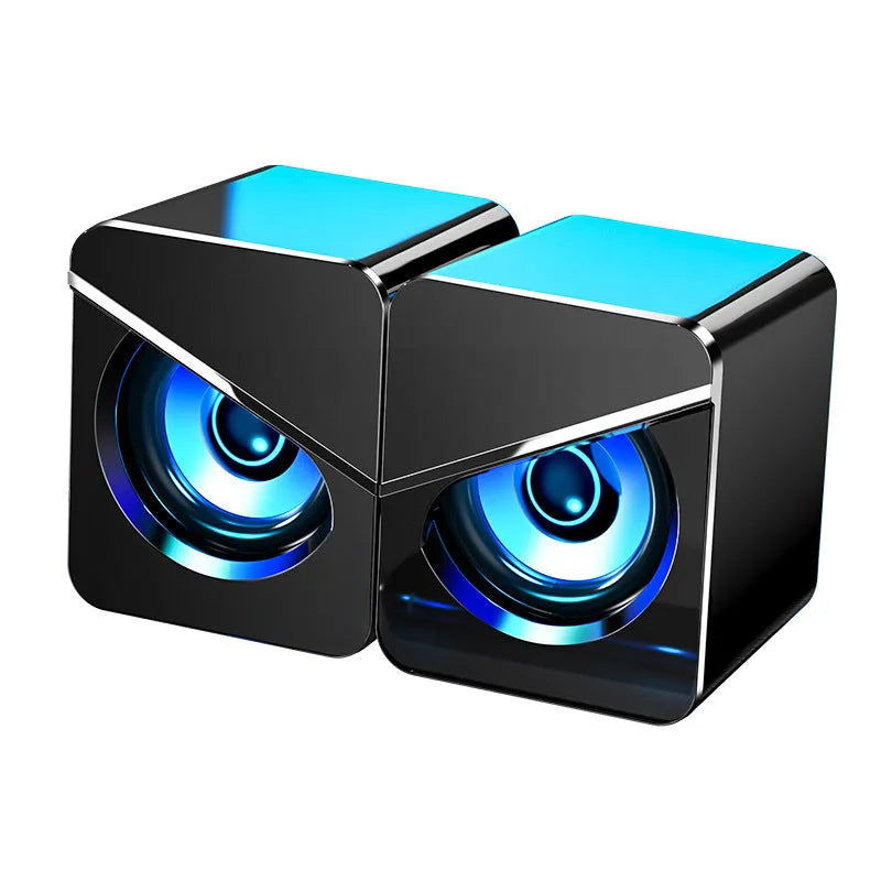 Small black and white desktop computer speakers with USB cable and 3.5mm audio connector
