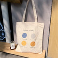 Orange geometric print women's canvas tote bag with zip top and shoulder straps.
