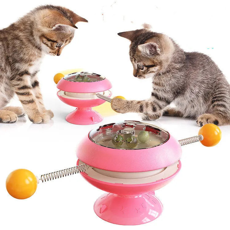 Rotating turntable cat toy with transparent compartment containing catnip balls and suction cup base
