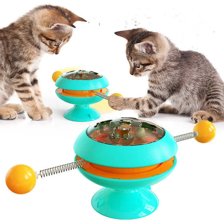 Rotating turntable cat toy with transparent compartment containing catnip balls and suction cup base