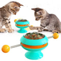 Rotating turntable cat toy with transparent compartment containing catnip balls and suction cup base