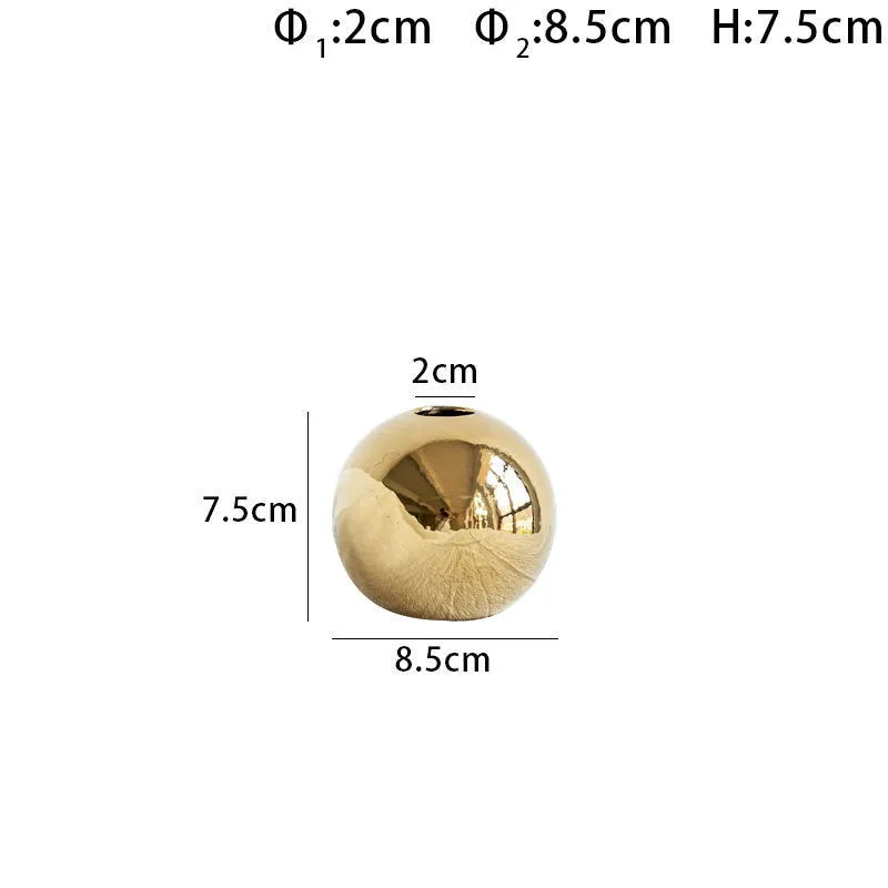 Handmade ceramic gold electroplated spherical vase on a table as home decor