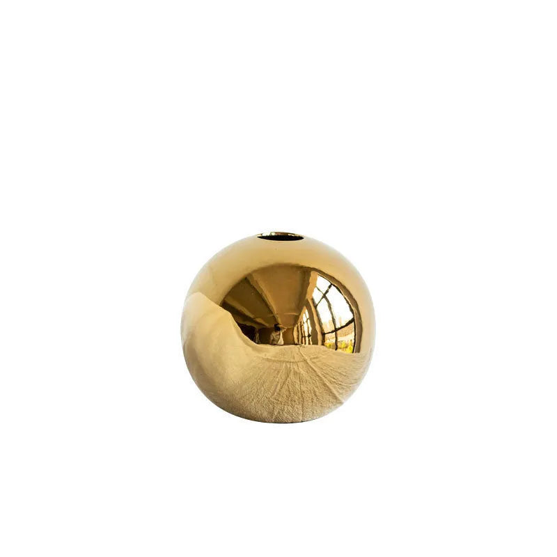 Handmade ceramic gold electroplated spherical vase on a table as home decor