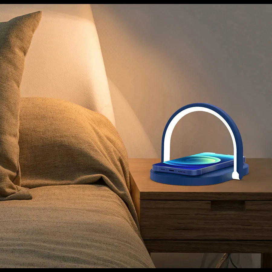 Black wireless charging pad with night light and integrated phone holder on a wooden desk.