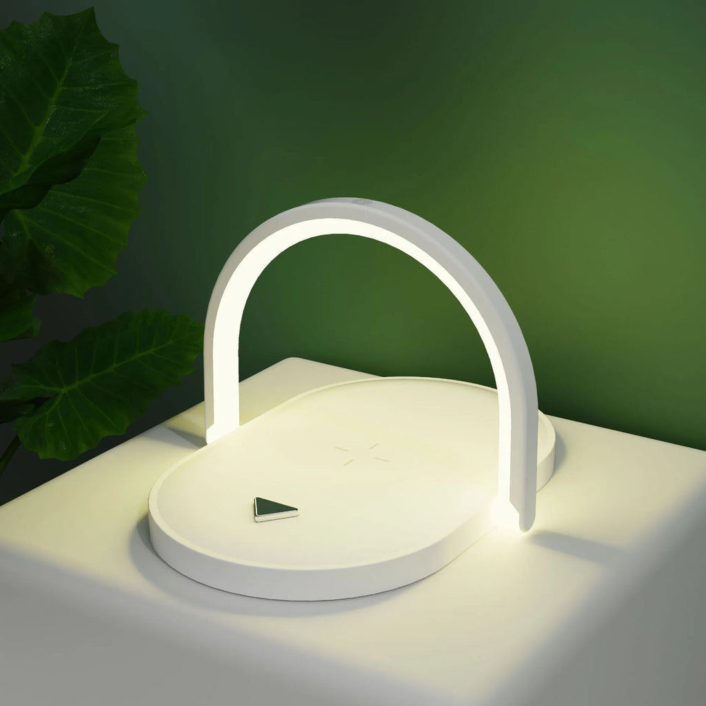 Black wireless charging pad with night light and integrated phone holder on a wooden desk.