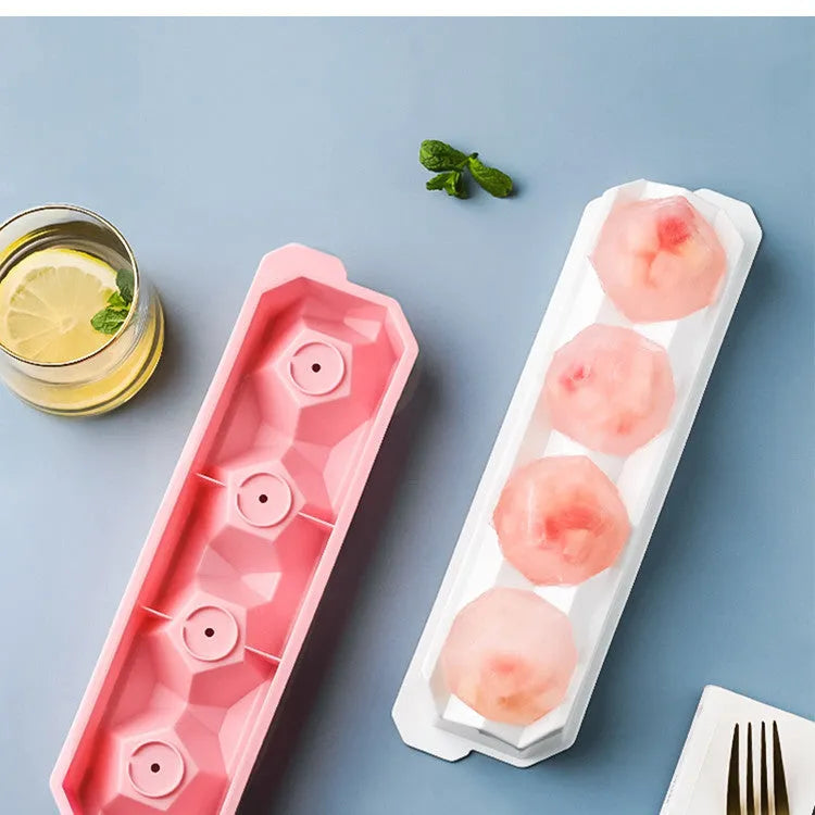 Flexible silicone ice tray producing large hockey puck-shaped ice cubes and other decorative shapes like spheres and pentagons.