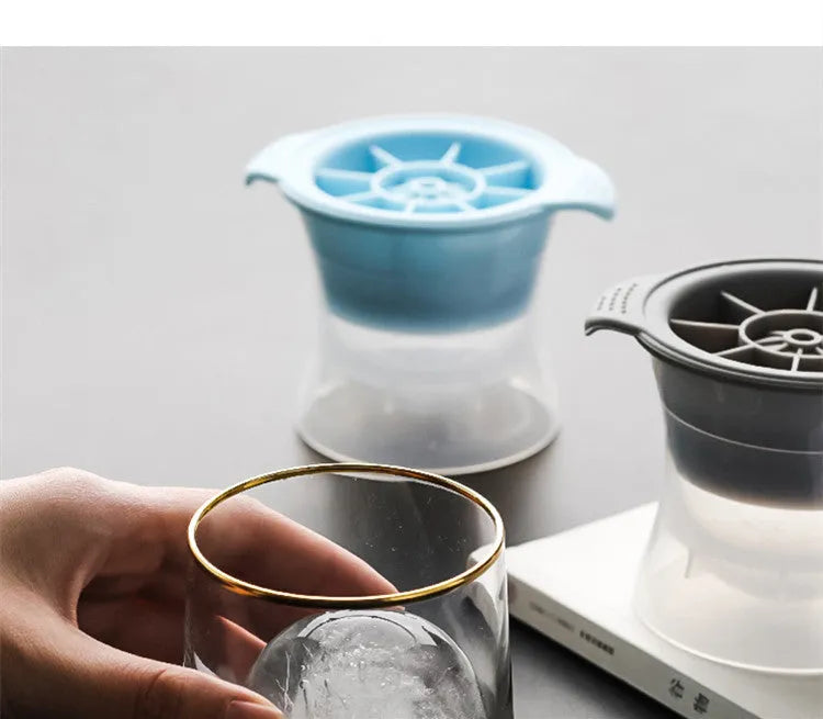 Flexible silicone ice tray producing large hockey puck-shaped ice cubes and other decorative shapes like spheres and pentagons.