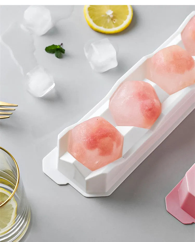 Flexible silicone ice tray producing large hockey puck-shaped ice cubes and other decorative shapes like spheres and pentagons.