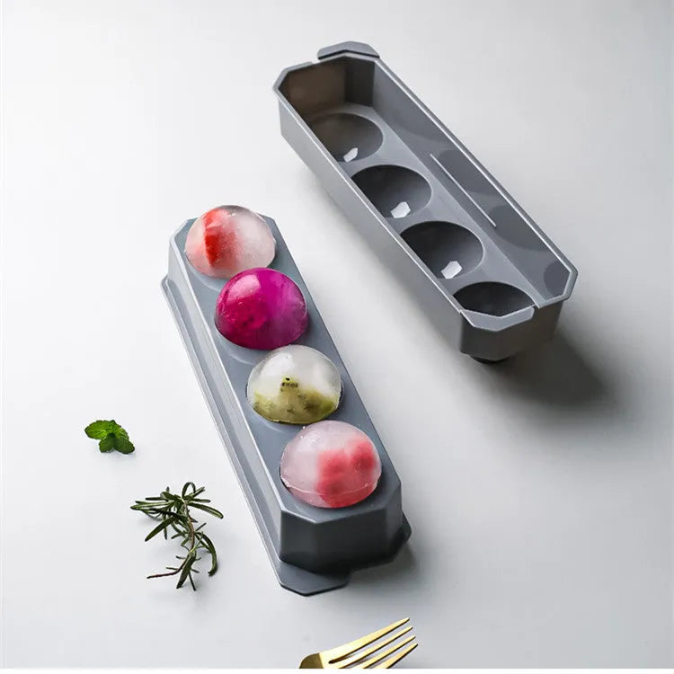 Flexible silicone ice tray producing large hockey puck-shaped ice cubes and other decorative shapes like spheres and pentagons.
