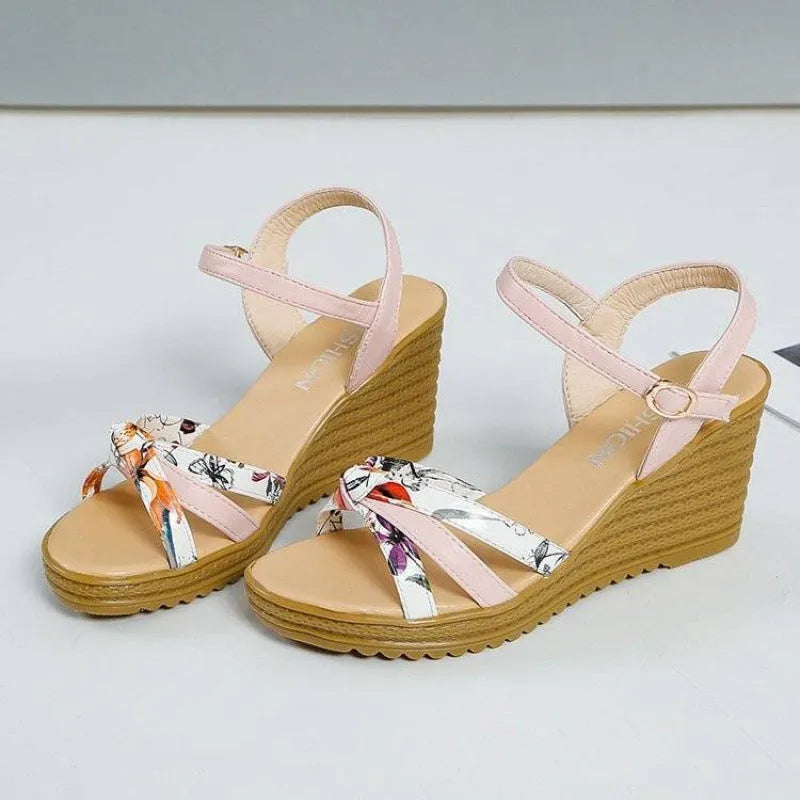Women's pink wedge sandals with a thick heel, fish mouth style, and a buckle strap.