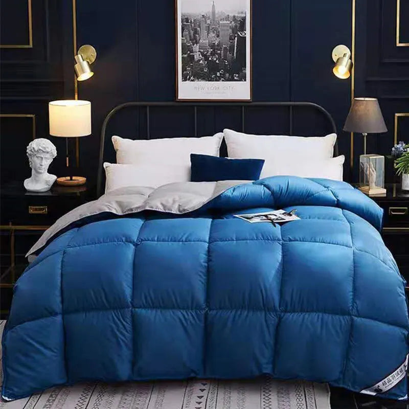 Goose down winter duvet in twill fabric shown in a light grey colour on a bed.