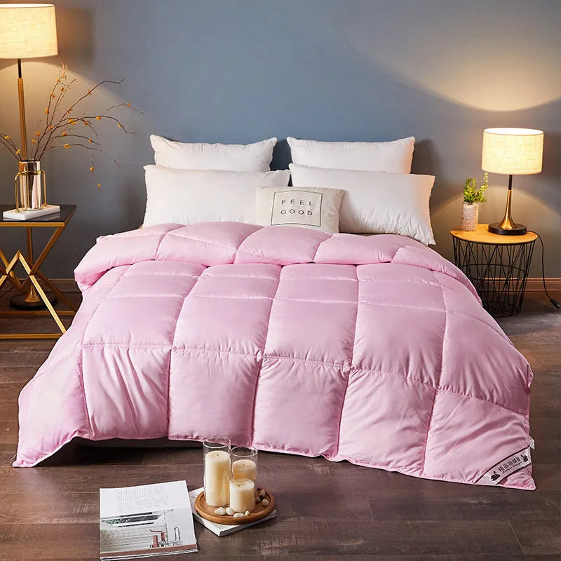 Goose down winter duvet in twill fabric shown in a light grey colour on a bed.