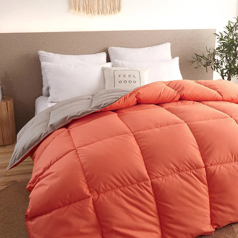 Goose down winter duvet in twill fabric shown in a light grey colour on a bed.