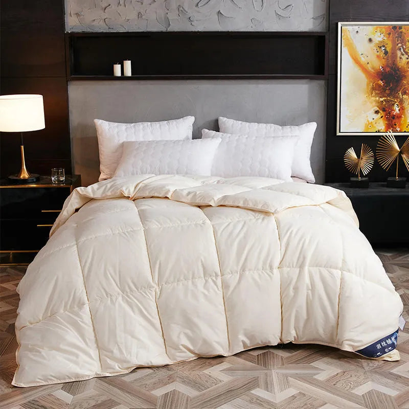 Goose down winter duvet in twill fabric shown in a light grey colour on a bed.