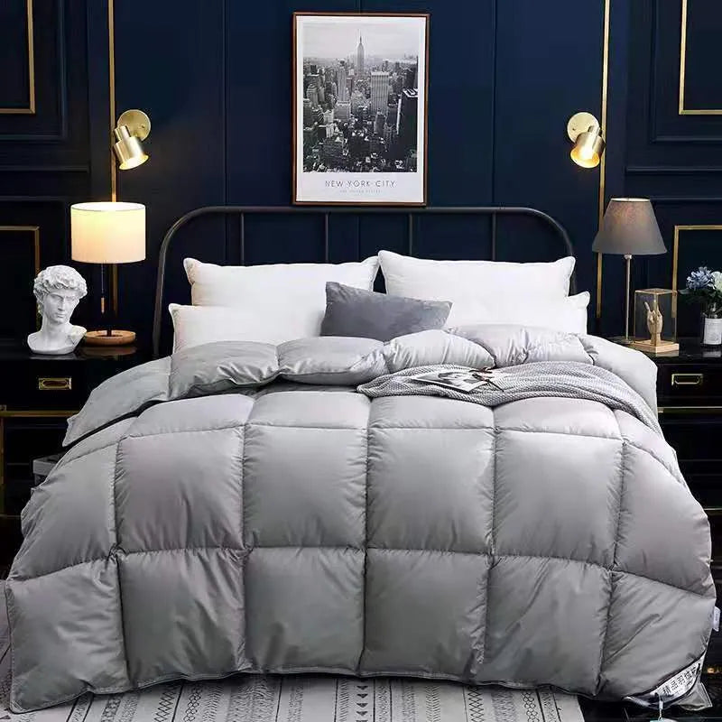 Goose down winter duvet in twill fabric shown in a light grey colour on a bed.