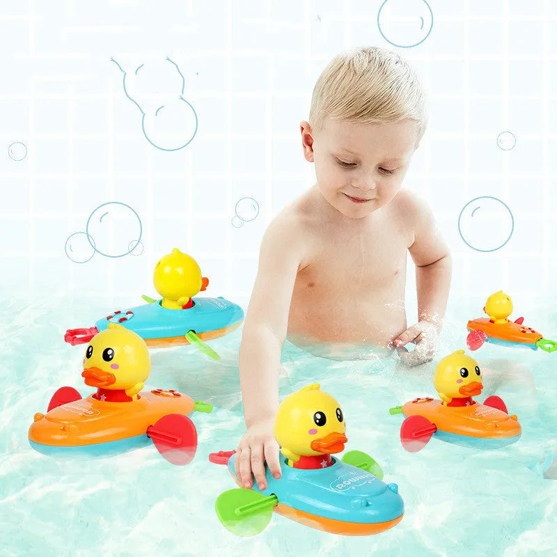 Yellow plastic wind-up duck bath toy swimming in water.