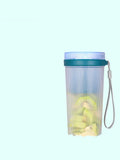 Small pink and green portable electric juicer cup with USB charging cable.