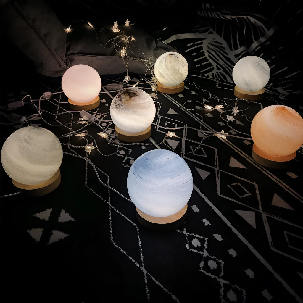 Nordic style USB table lamp with a glass shade shown in a choice of colours on a bedside table.
