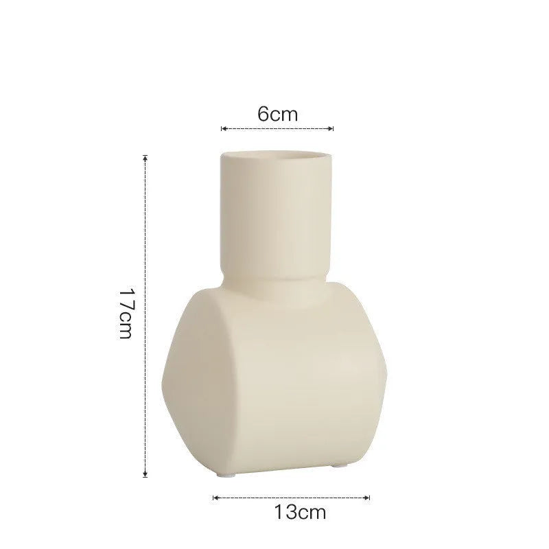 Hammered ceramic vase in a soft Morandi colour glaze on a wooden surface.