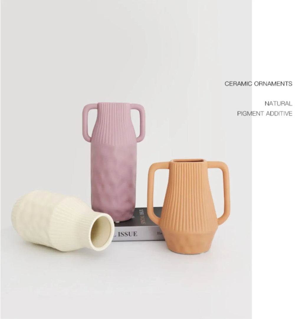 Hammered ceramic vase in a soft Morandi colour glaze on a wooden surface.