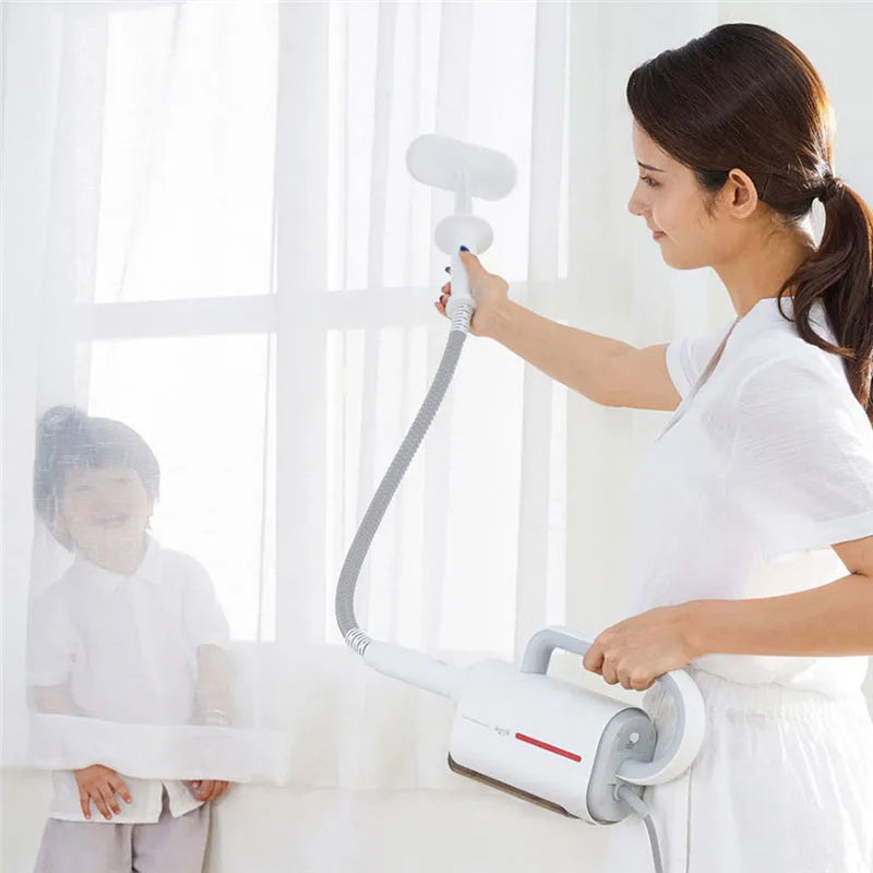 Deerma DEM-ZQ610 white steam cleaner main unit with brush heads, glass scraper, and mop attachments on a table.