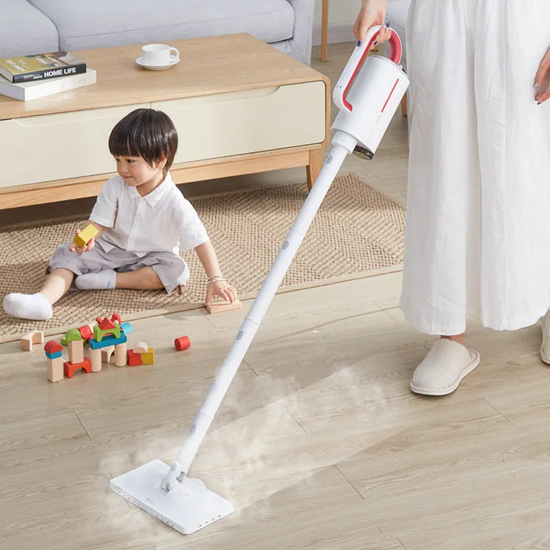Deerma DEM-ZQ610 white steam cleaner main unit with brush heads, glass scraper, and mop attachments on a table.