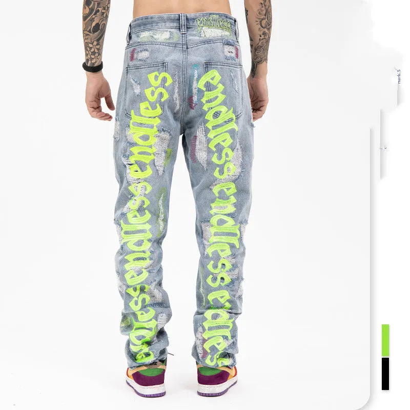 Ripped retro jeans trousers for men and women, straight loose fit, black, with embroidery and frayed details on a model standing outdoors