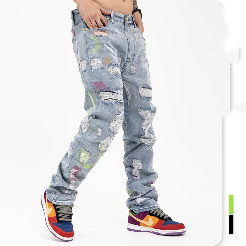 Ripped retro jeans trousers for men and women, straight loose fit, black, with embroidery and frayed details on a model standing outdoors