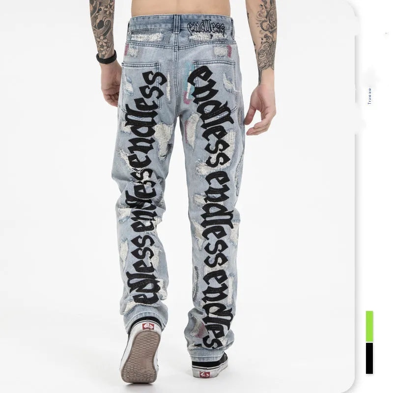 Ripped retro jeans trousers for men and women, straight loose fit, black, with embroidery and frayed details on a model standing outdoors