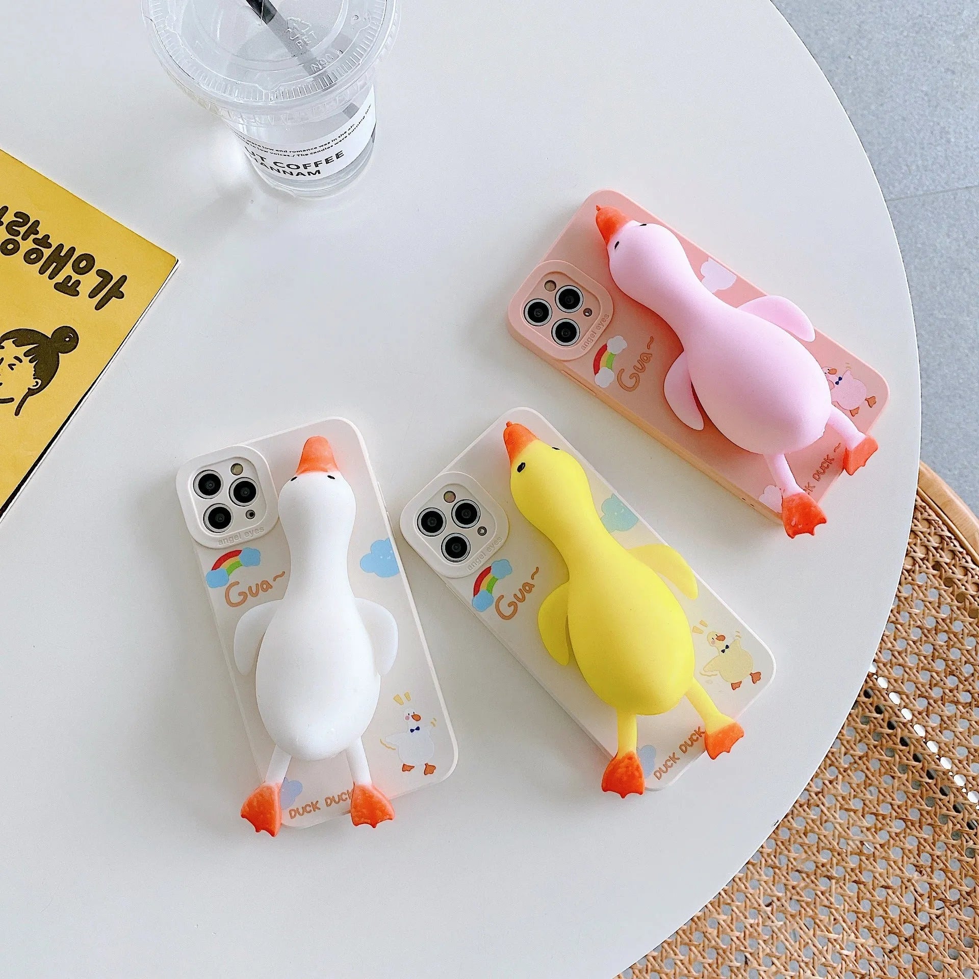 Pinch duck cartoon print silicone protective case for iPhone in yellow, white, or pink.