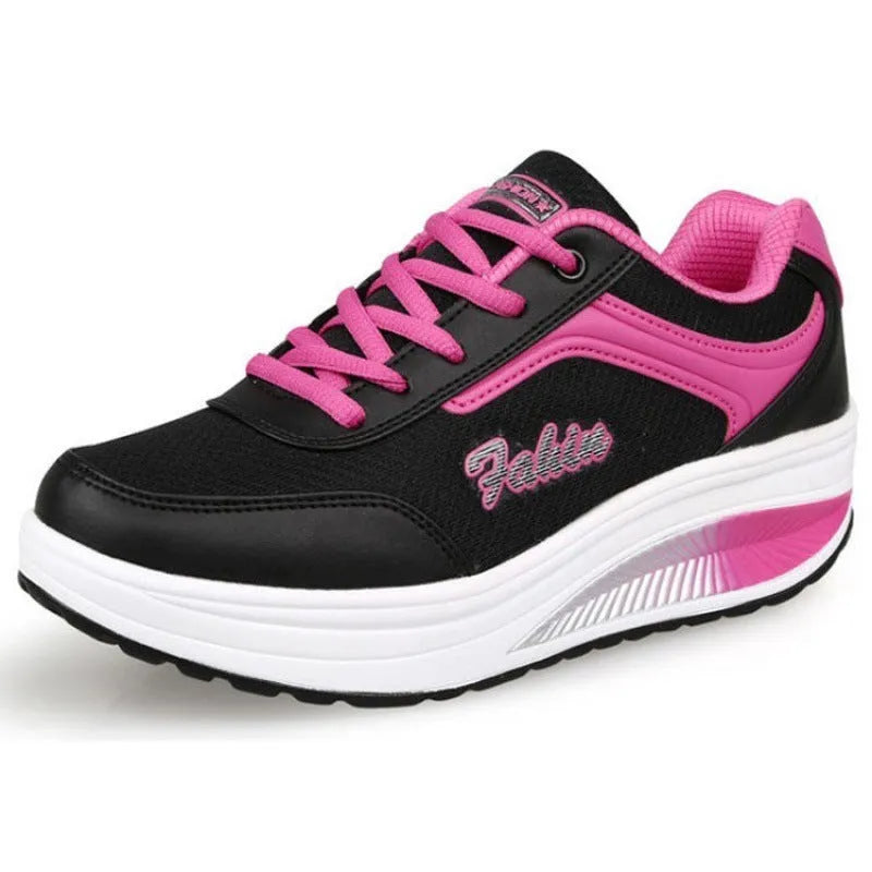 Women's grey powder heelless sports shoes with a middle heel on a plain background.