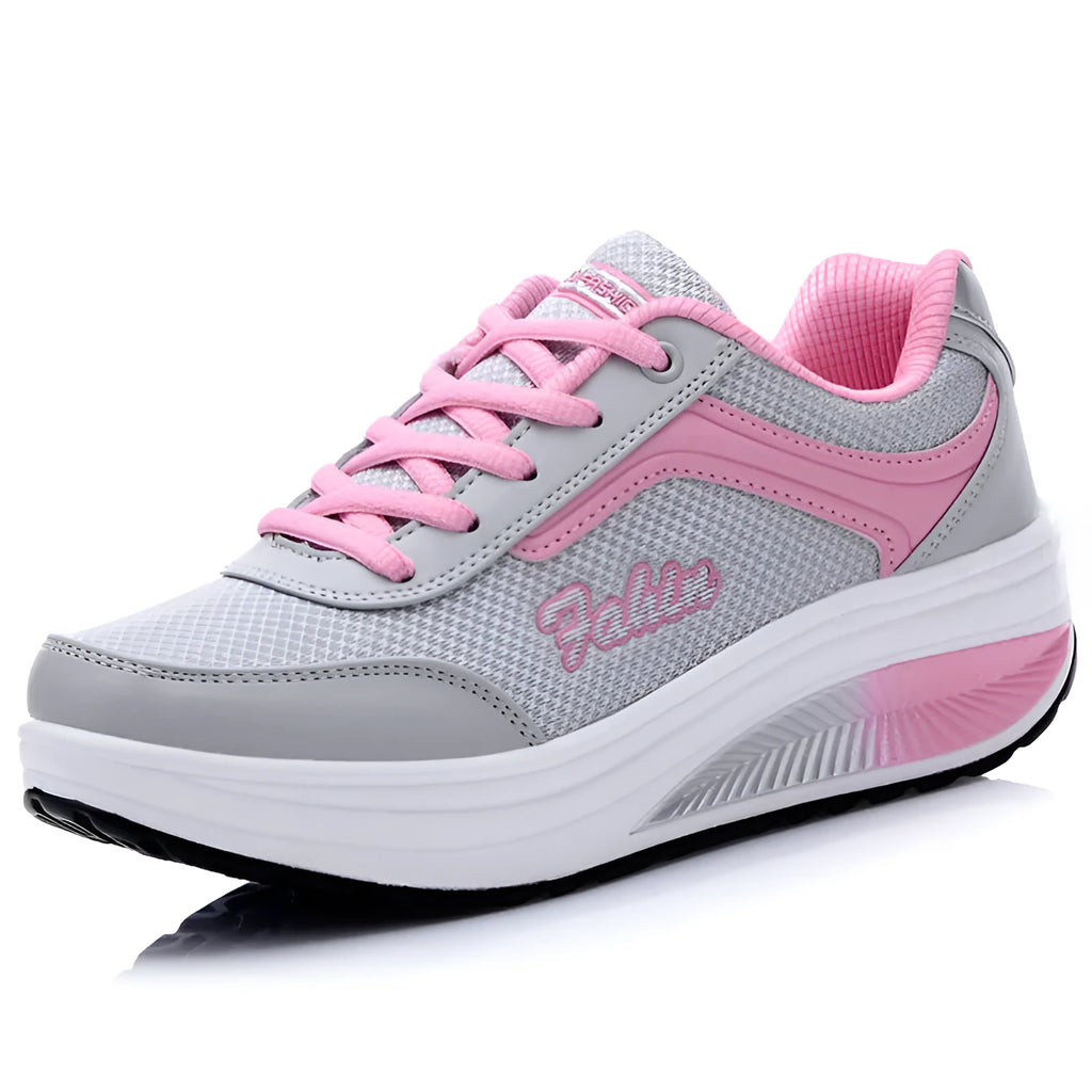 Women's grey powder heelless sports shoes with a middle heel on a plain background.