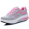 Women's grey powder heelless sports shoes with a middle heel on a plain background.