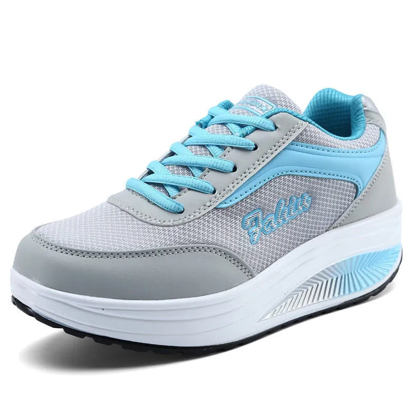 Women's grey powder heelless sports shoes with a middle heel on a plain background.