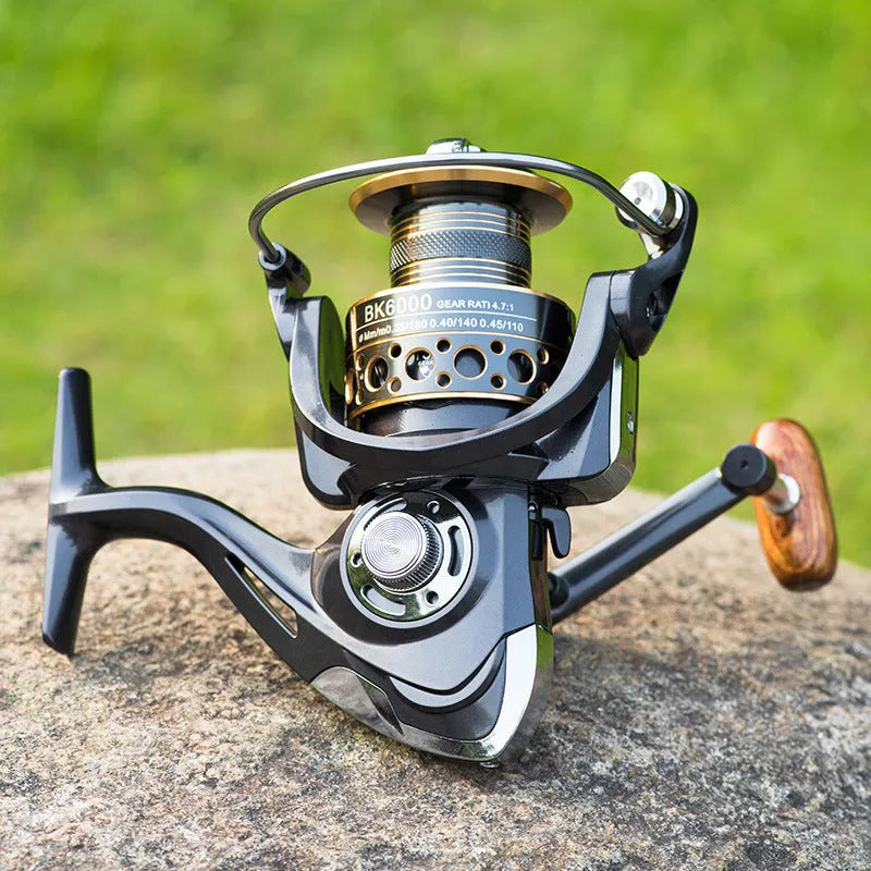 Telescopic carbon fibre fishing rod with spinning reel, solid wood handle, and metal wire cup on a rocky shore