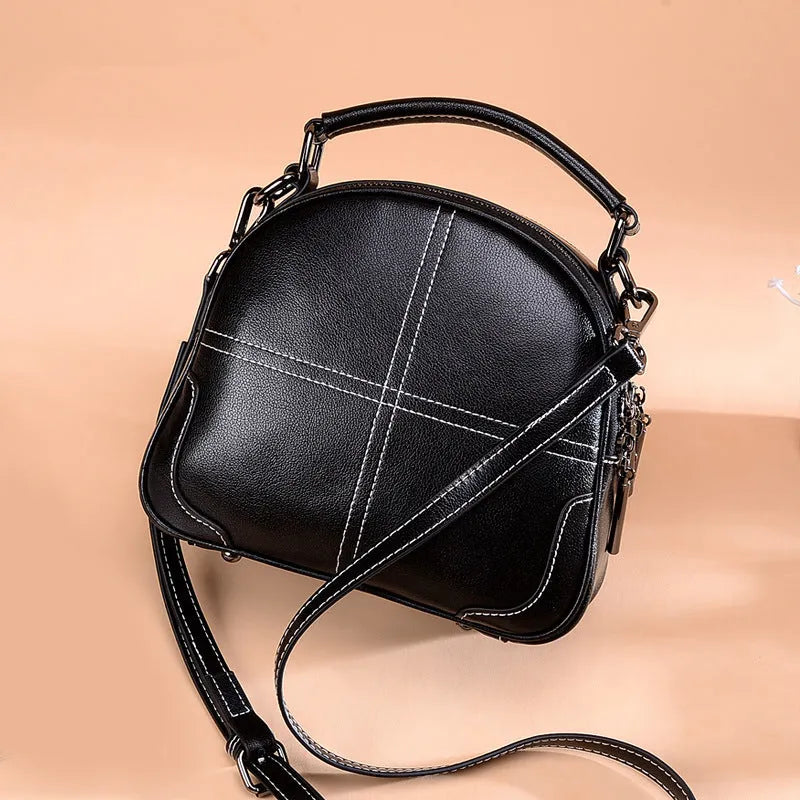 Round cowhide leather handbag with zipper closure and double strap in wine red