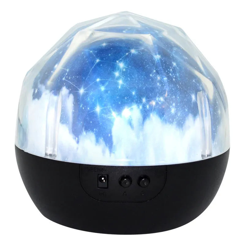 Compact plastic starry sky projector showing cosmic projection on a wall with USB cable.