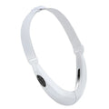 White multifunctional facial lifting instrument with red and blue light therapy and vibration modes on a flat surface