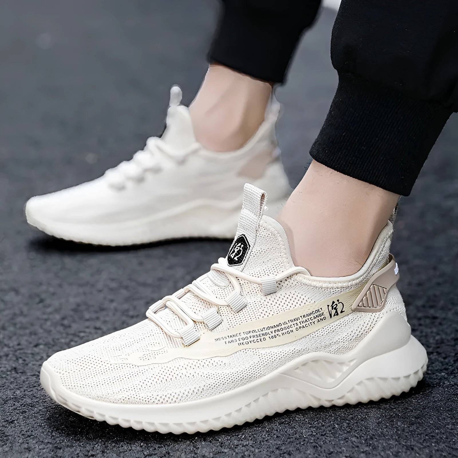 Men's white low-top sports shoes with mesh upper and rubber sole on a plain background.