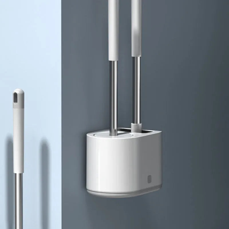 White silicone toilet brush set with long handle, soft TPR head, and second cleaning brush on a bathroom floor