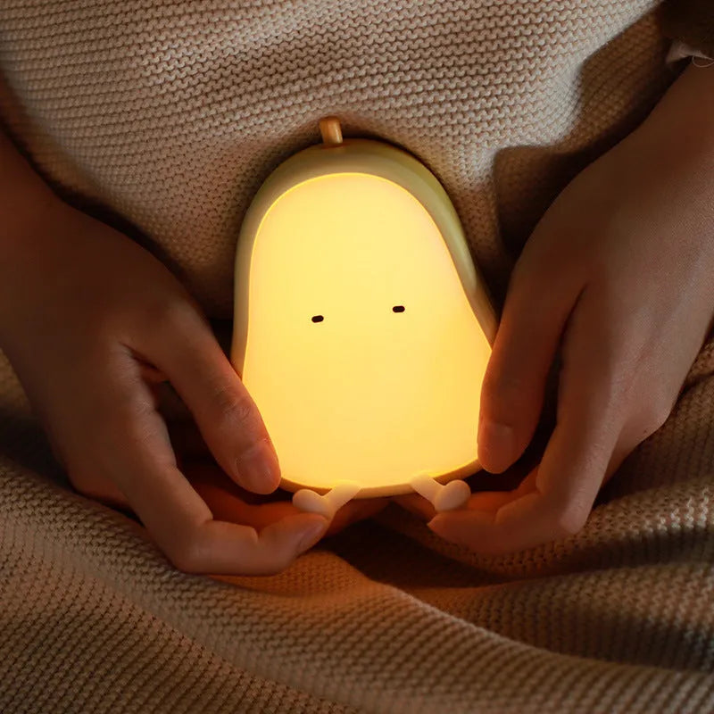 Yali pear-shaped silicone night light with warm yellow illumination on bedside table