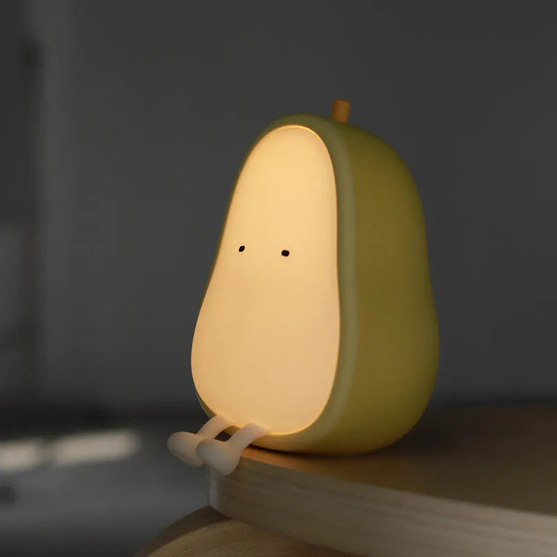 Yali pear-shaped silicone night light with warm yellow illumination on bedside table