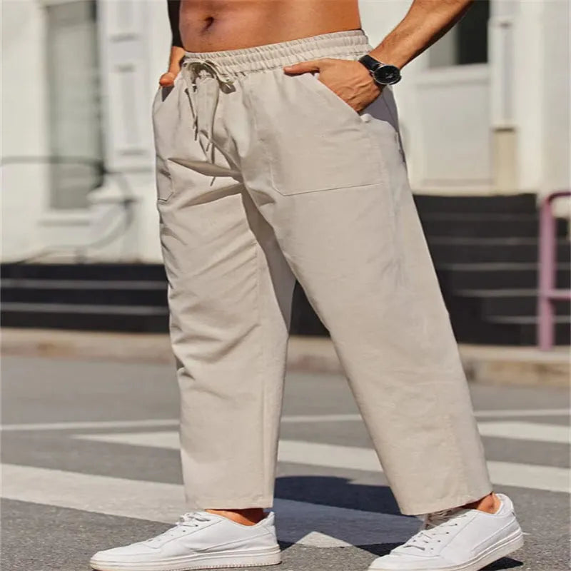 Men's straight-leg linen trousers in a solid colour, showing the elasticated mid waist and long leg.