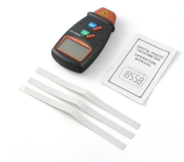 Digital tachometer in dark grey ABS plastic with 5-digit LCD display and black buttons on white background