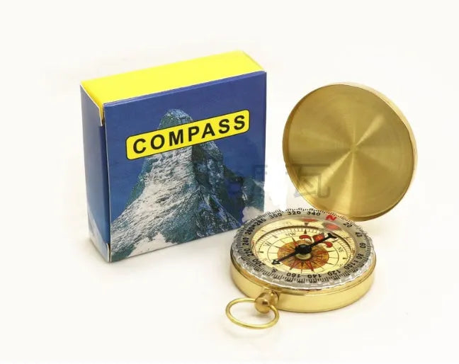 Gold metal flip compass with open lid showing compass face, pocket watch style