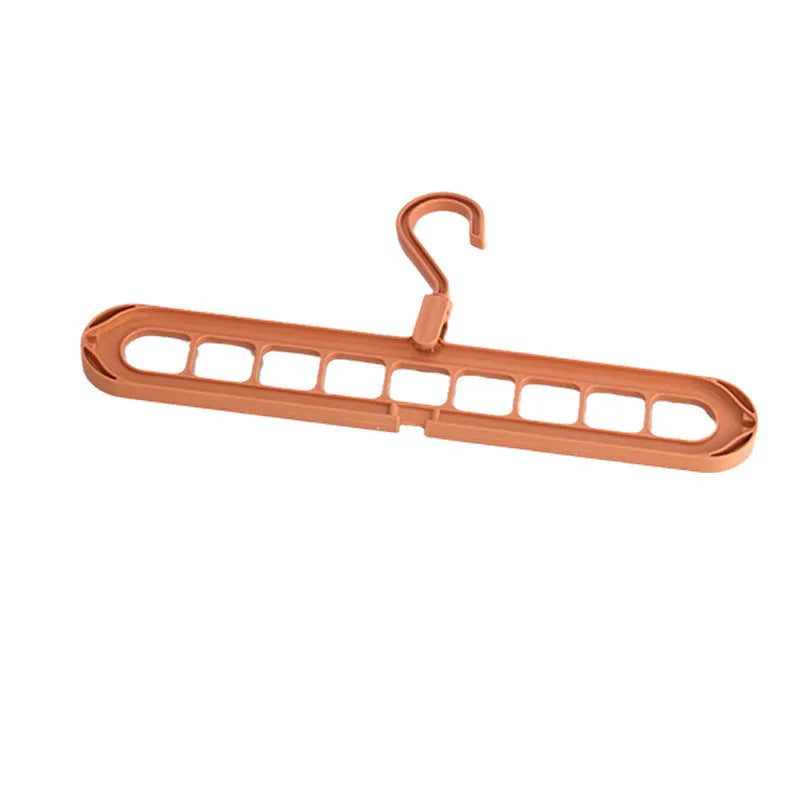 Green plastic nine-hole multifunctional clothes hanger for trousers on a white background.