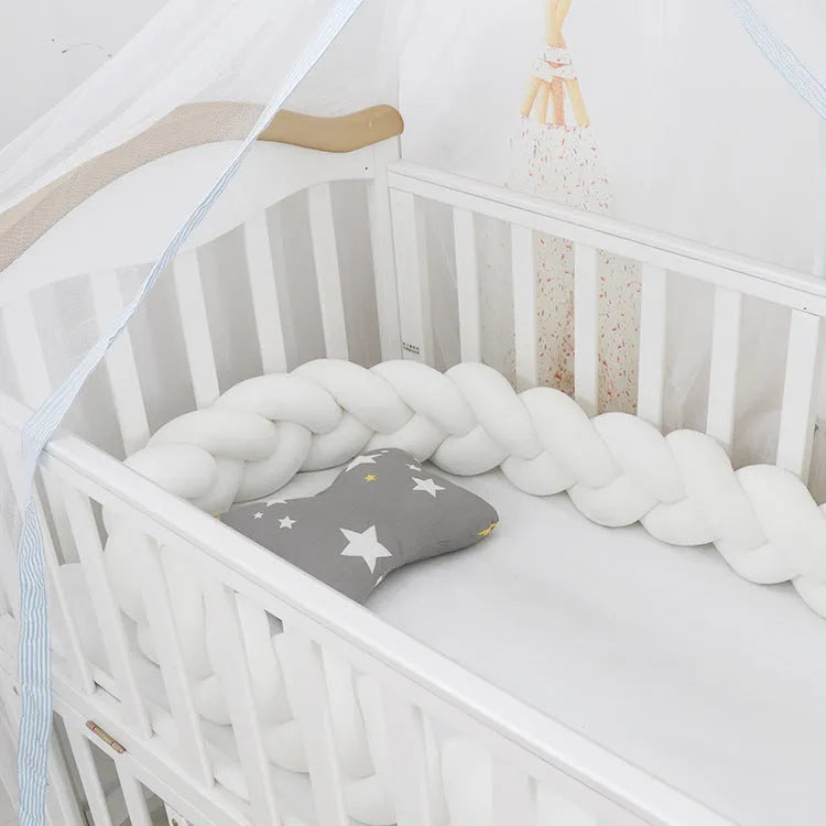Baby cot bumper braid in spandex crystal velvet, shown in a light grey colour, wrapped around white crib rails.