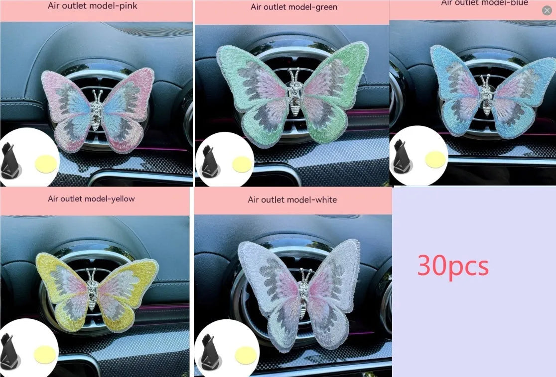 Fabric embroidered butterfly car air vent decoration in multiple colour options on a dashboard.