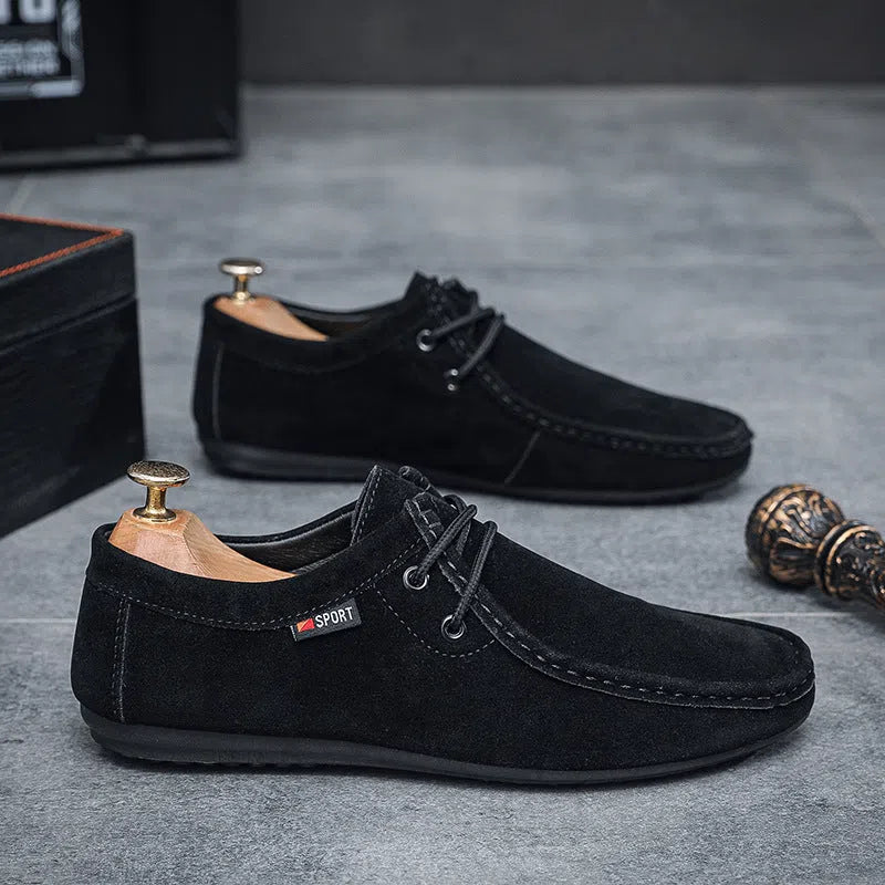 Men's black slip-on loafers with soft sole, round toe, and stitching detail on a neutral background